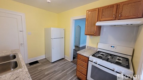 A kitchen with a white stove top oven and a white refrigerator.