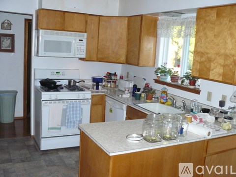 A kitchen with a white oven and a white microwave.