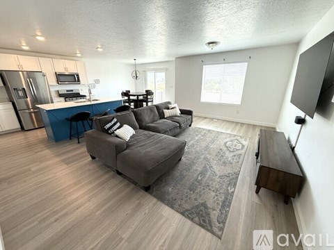 A living room with a grey couch and a wooden floor.