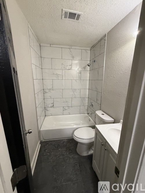A bathroom with a toilet, sink, and bathtub.