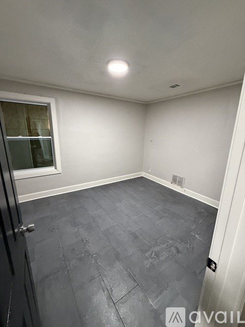 A room with a tiled floor and a window.