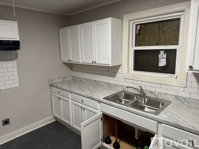 A room with a window and tiled floor.