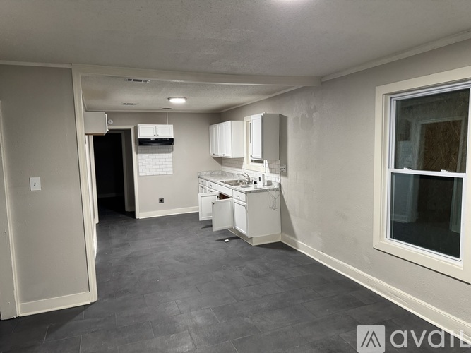 A kitchen area with a refrigerator, microwave, and a dishwasher.