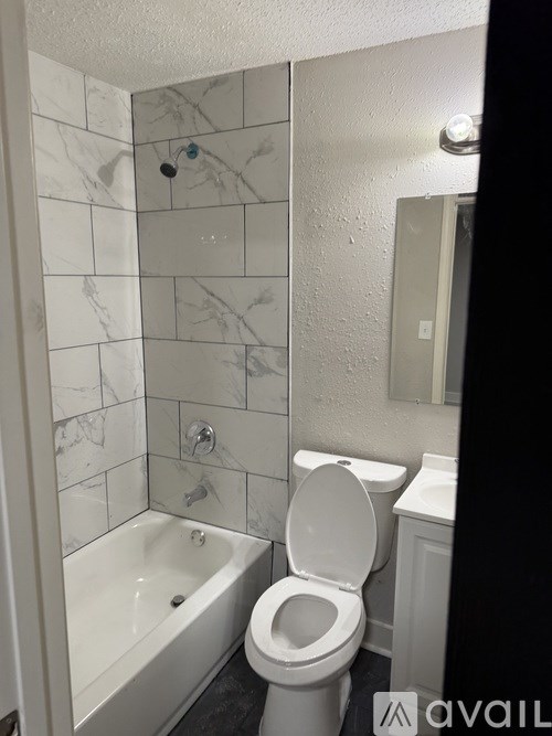 A white toilet in a bathroom with marble tiles.