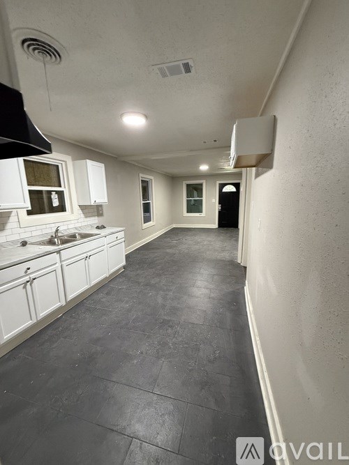 A long hallway with a black floor and white walls.