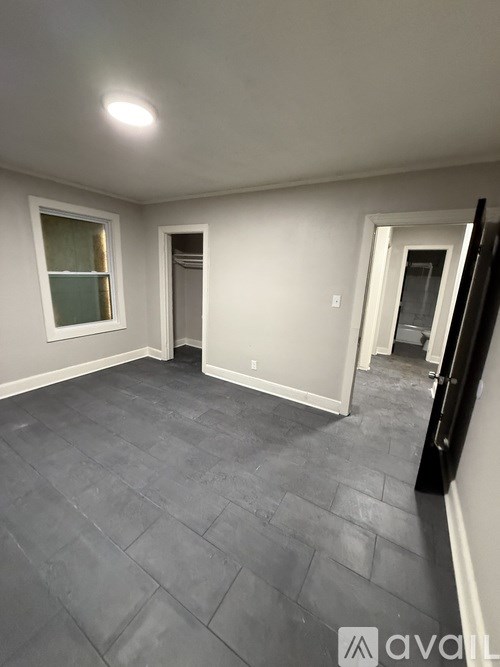 A room with grey tiled flooring and white walls.