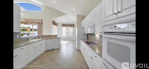 A kitchen with white cabinets and a stainless steel oven.