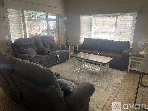 A living room with grey furniture and a large window.