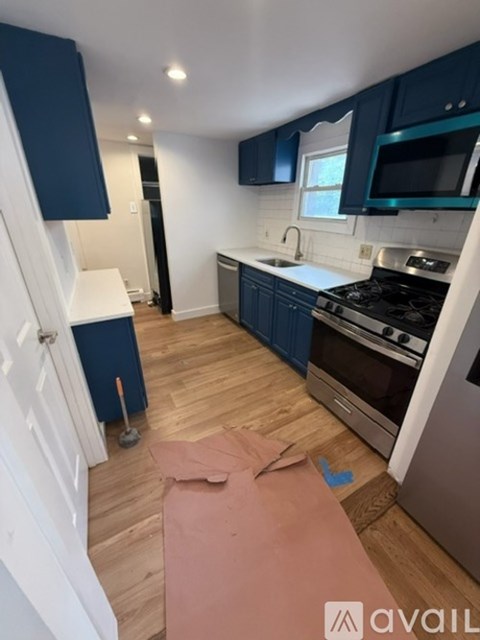 A kitchen with blue cabinets and a white fridge.