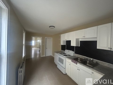 A kitchen with white cabinets and a black countertop.