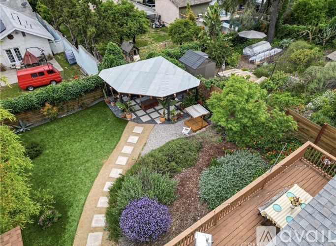 A backyard with a wooden deck and a gazebo.