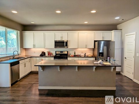 A modern kitchen with white cabinets and a central island.