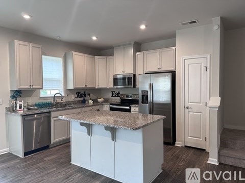 A kitchen with a granite countertop and stainless steel appliances.