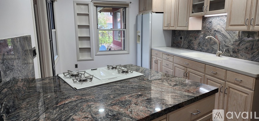 A kitchen with granite countertops and wooden cabinets.