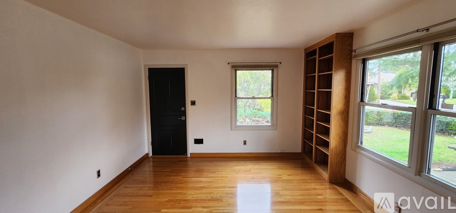 A room with wooden floors and a large window.