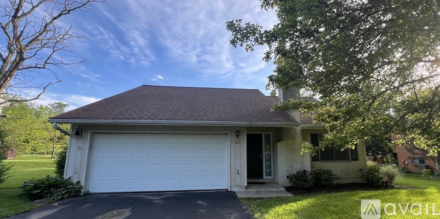 A house with a brown roof and a white garage door.