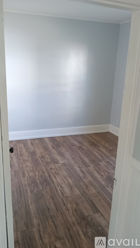 A room with wooden flooring and a white door.