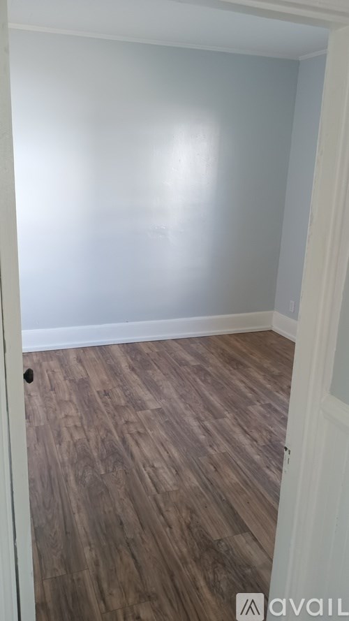 A room with wooden flooring and a white door.