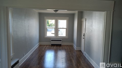 A room with a window and a door is available for rent.