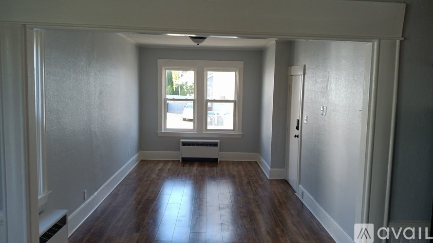 A room with a window and a door is available for rent.