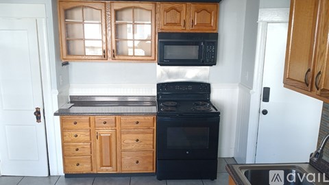 A kitchen with wooden cabinets and black appliances.