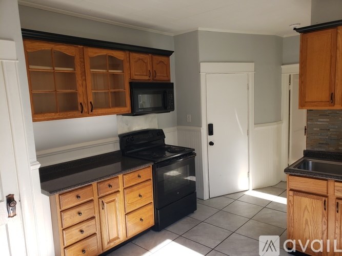 A kitchen with wooden cabinets and black appliances.