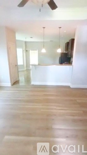 A room with wooden floors and a ceiling fan.