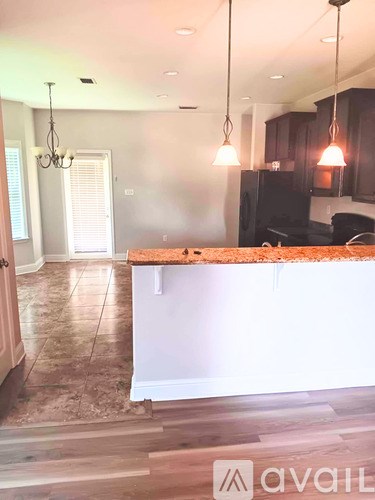 A kitchen with a white island and dark brown cabinets.