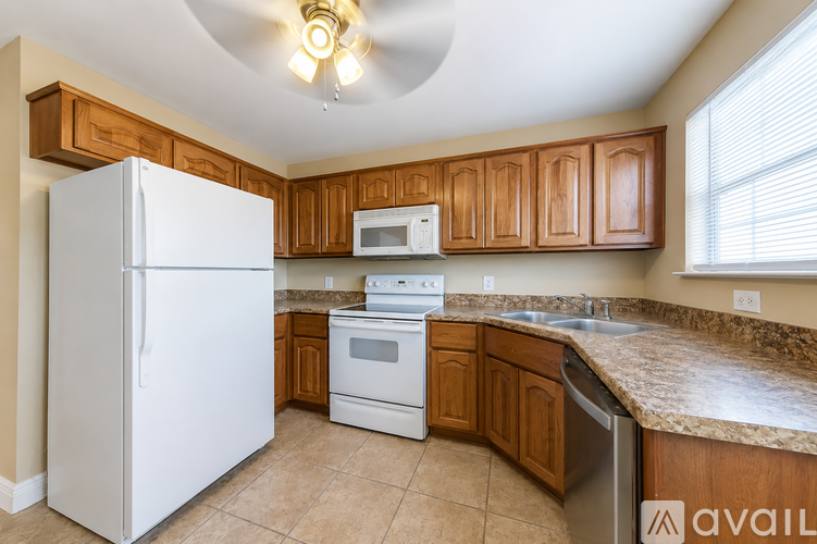A kitchen with wooden cabinets and a white refrigerator.