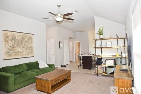 A living room with a green couch and a wooden coffee table.