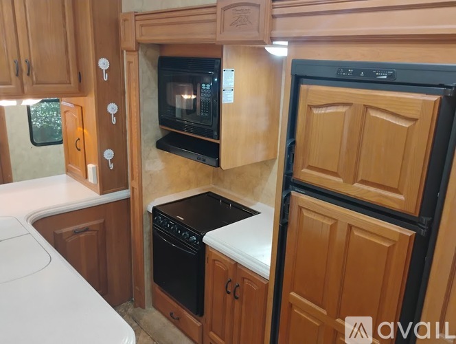 A kitchen with wooden cabinets and black appliances.