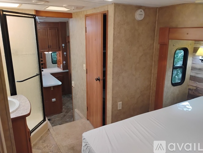 A bedroom with a bed, a sink, and a window.