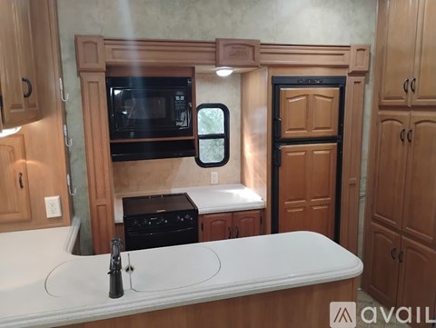 A kitchen with a white countertop and wooden cabinets.