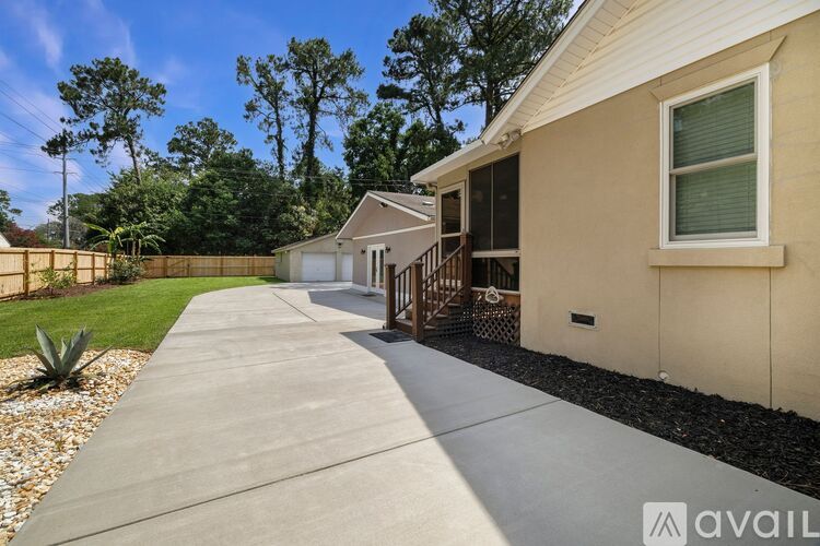 A house with a concrete walkway leading to the front door.