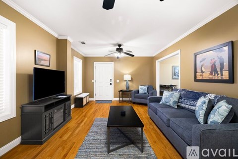 A living room with a black television and a grey couch.