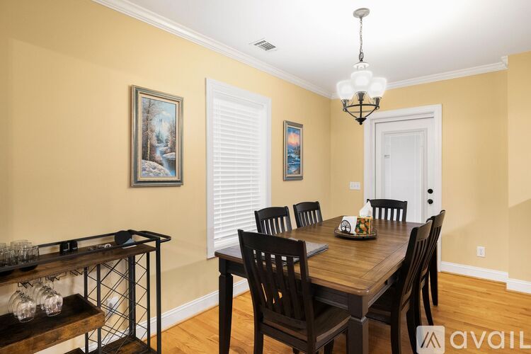 A dining room with a wooden table and chairs.
