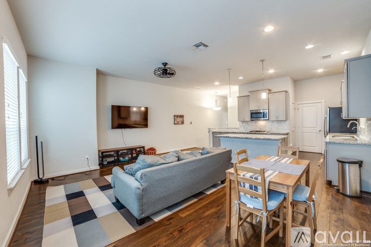 A living room with a grey couch and a wooden dining table.