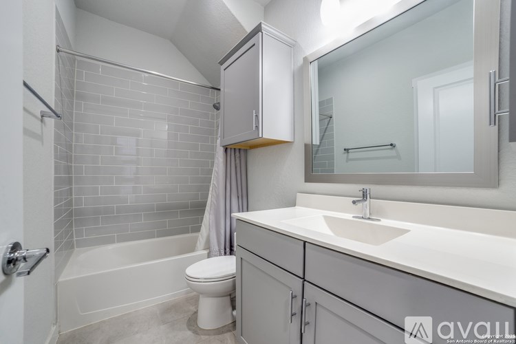 A bathroom with a white sink, toilet, and bathtub.