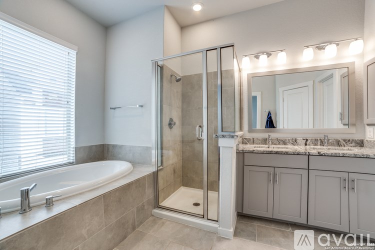 A bathroom with a tub, sink, and mirror.