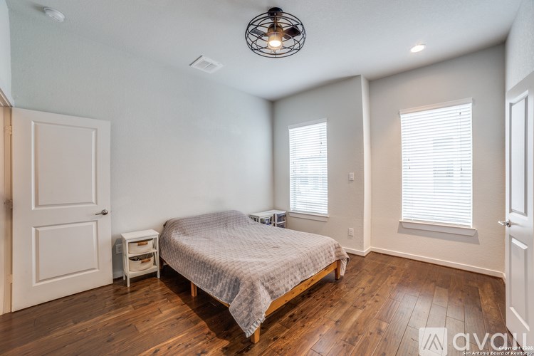 A bedroom with a bed, nightstand, and window.