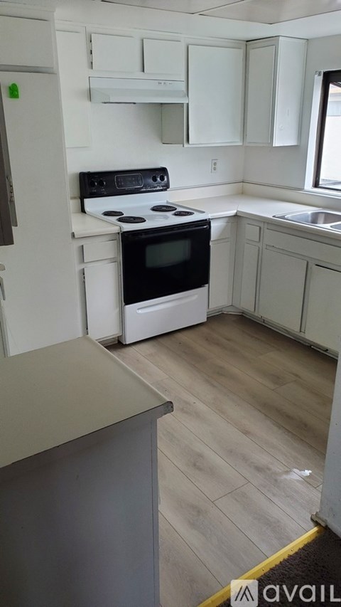 A kitchen with a stove top oven and a refrigerator.