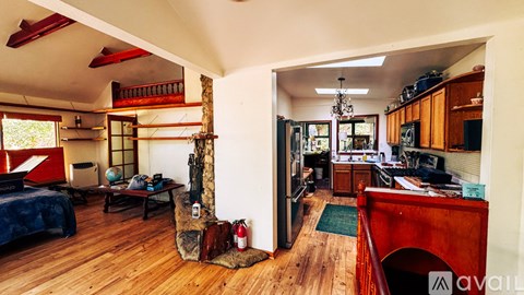 A living room with a blue couch and a wooden floor.