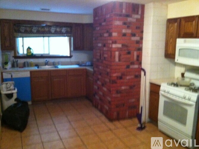 A kitchen with a red brick wall and a white stove.
