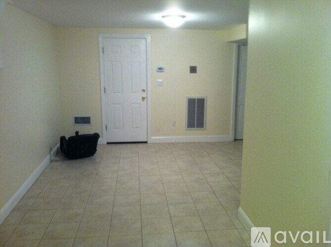 A room with a white door and a black dog bed.