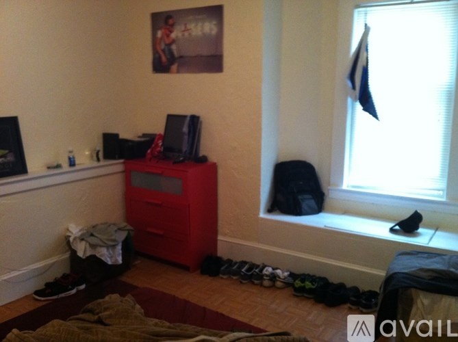 A room with a red cabinet and shoes scattered on the floor.