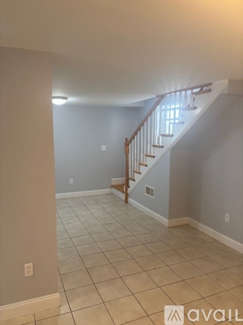 A room with a wooden floor and a staircase.