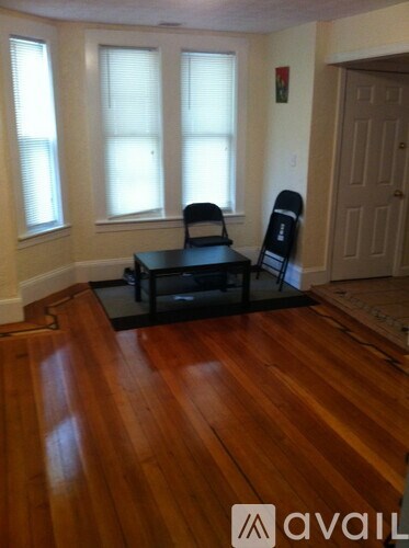 A room with a wooden floor and two chairs.