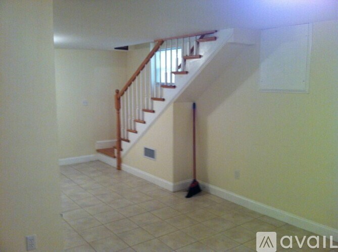 A room with a staircase and a broom.