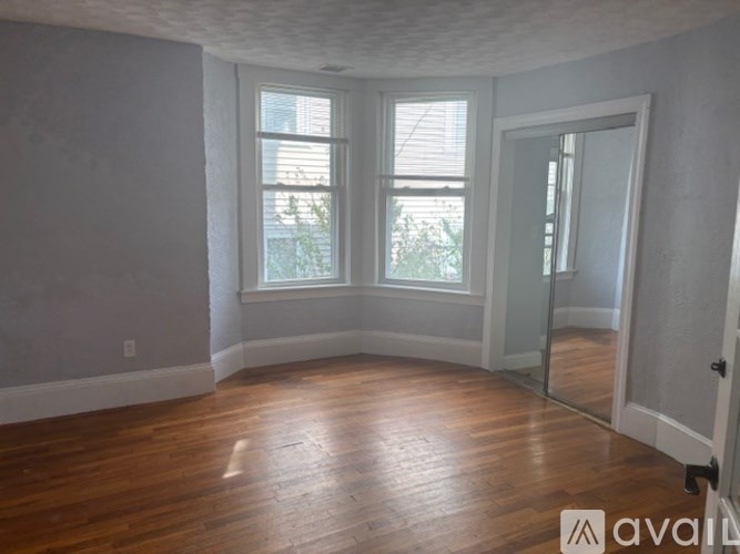 A white toilet in a bathroom with a brown shower curtain.