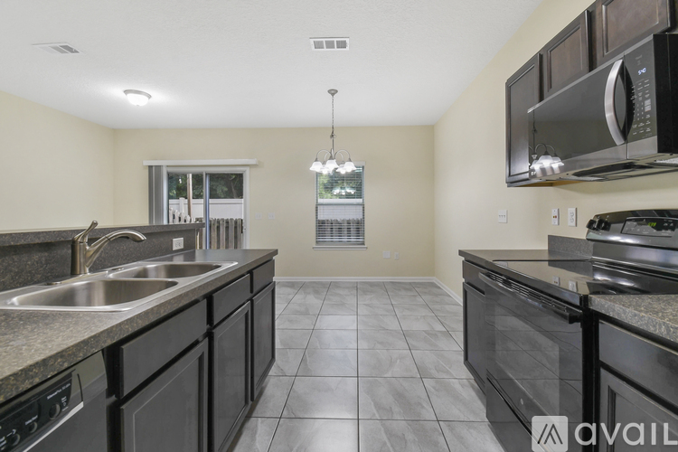 A kitchen with black cabinets and granite countertops.